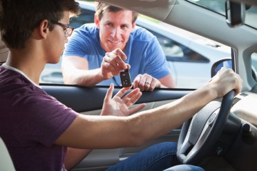 Father handing son car keys