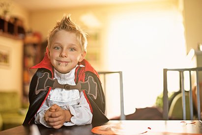 child dressed for trick or treating as a vampire